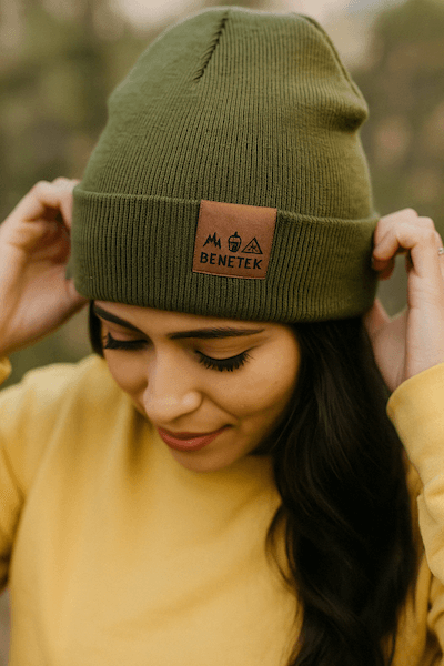 women wearing green beanie with brown clip label